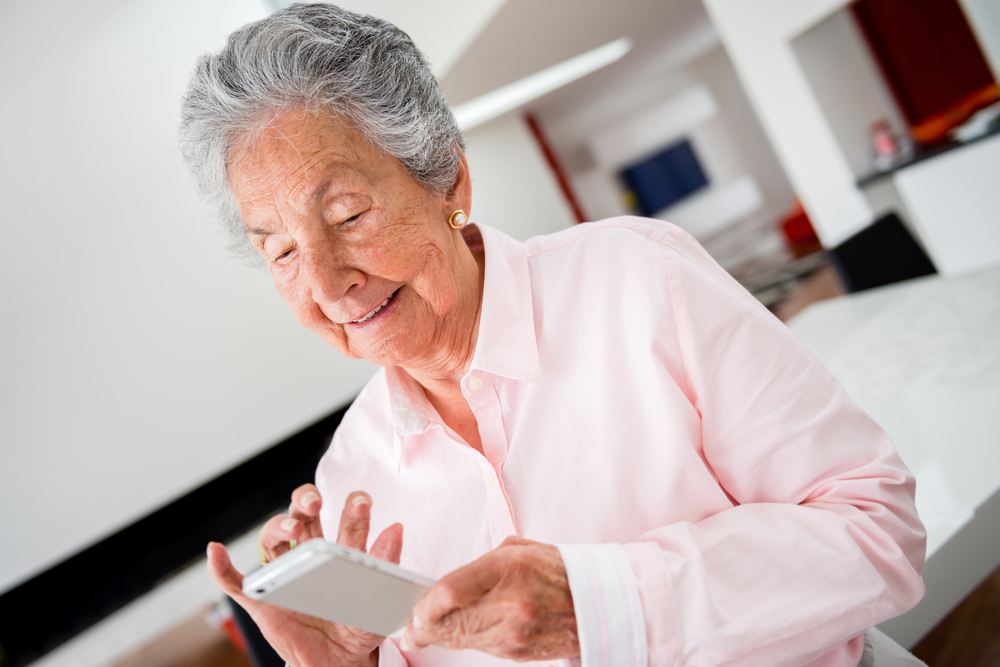 Happy senior woman using app on a cell phone-1